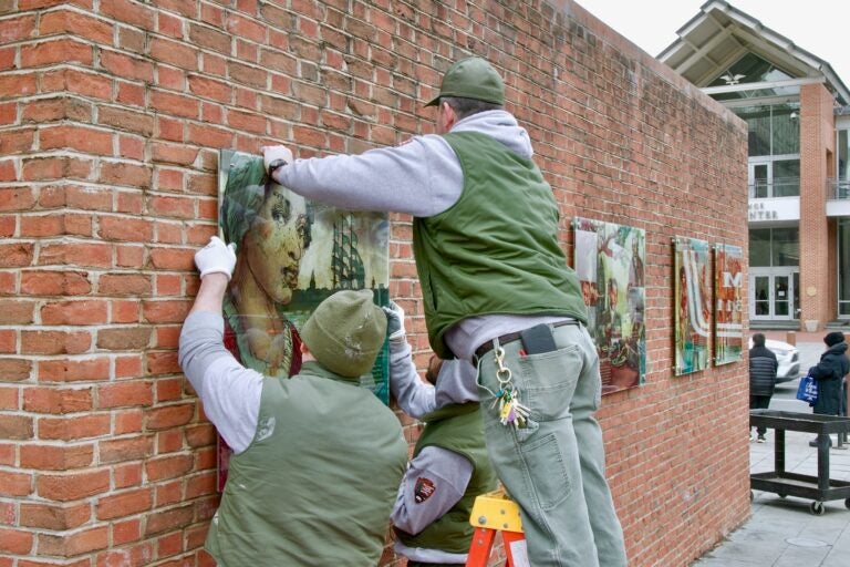 Workers are hanging the panels back up on the wall