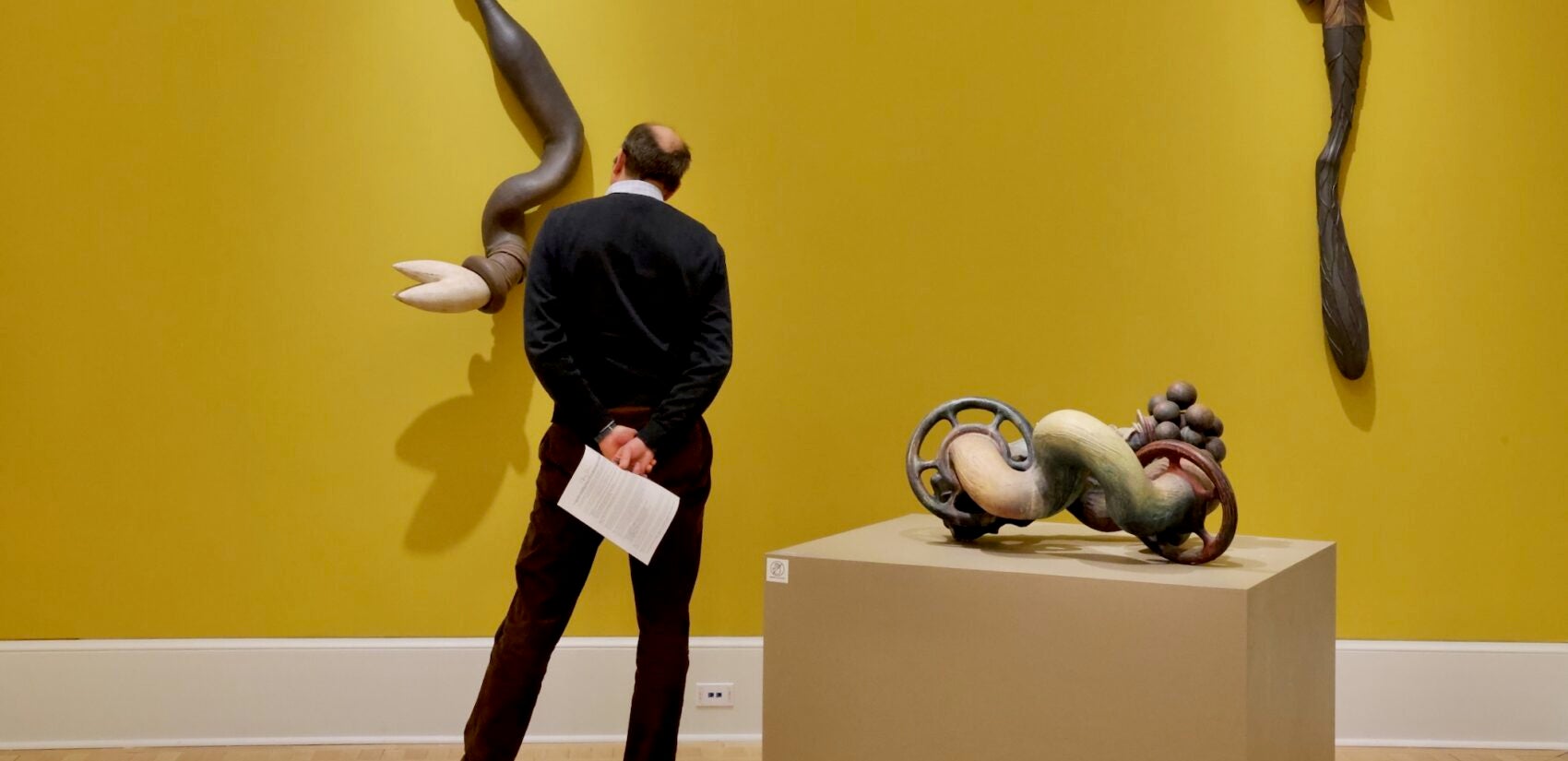 a person looks at an art piece in the Re-Union exhibit