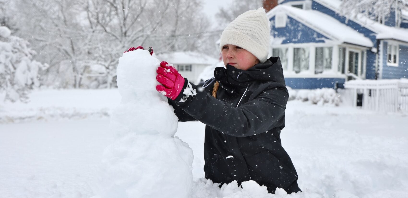 Bella Usle building a snowman during a massive snowstorm