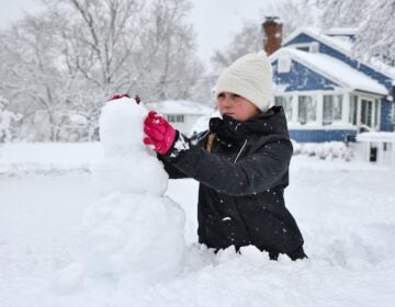 Bella Usle building a snowman during a massive snowstorm