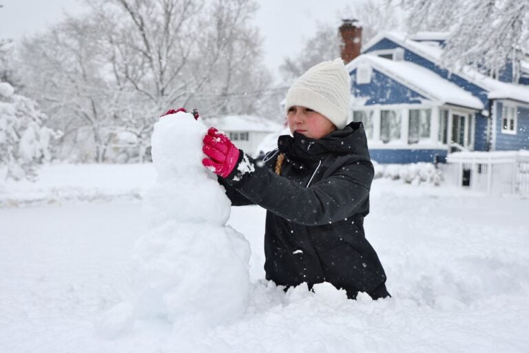 Bella Usle building a snowman during a massive snowstorm