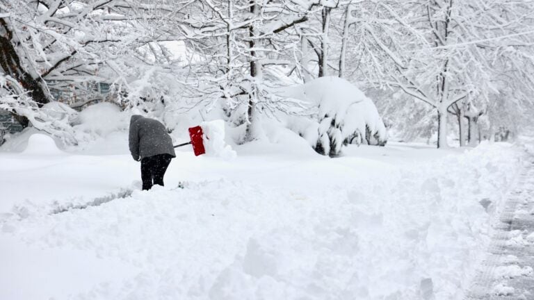 A person is shoveling a sidewalk after massive snowstorm in Moorestown, New Jersey