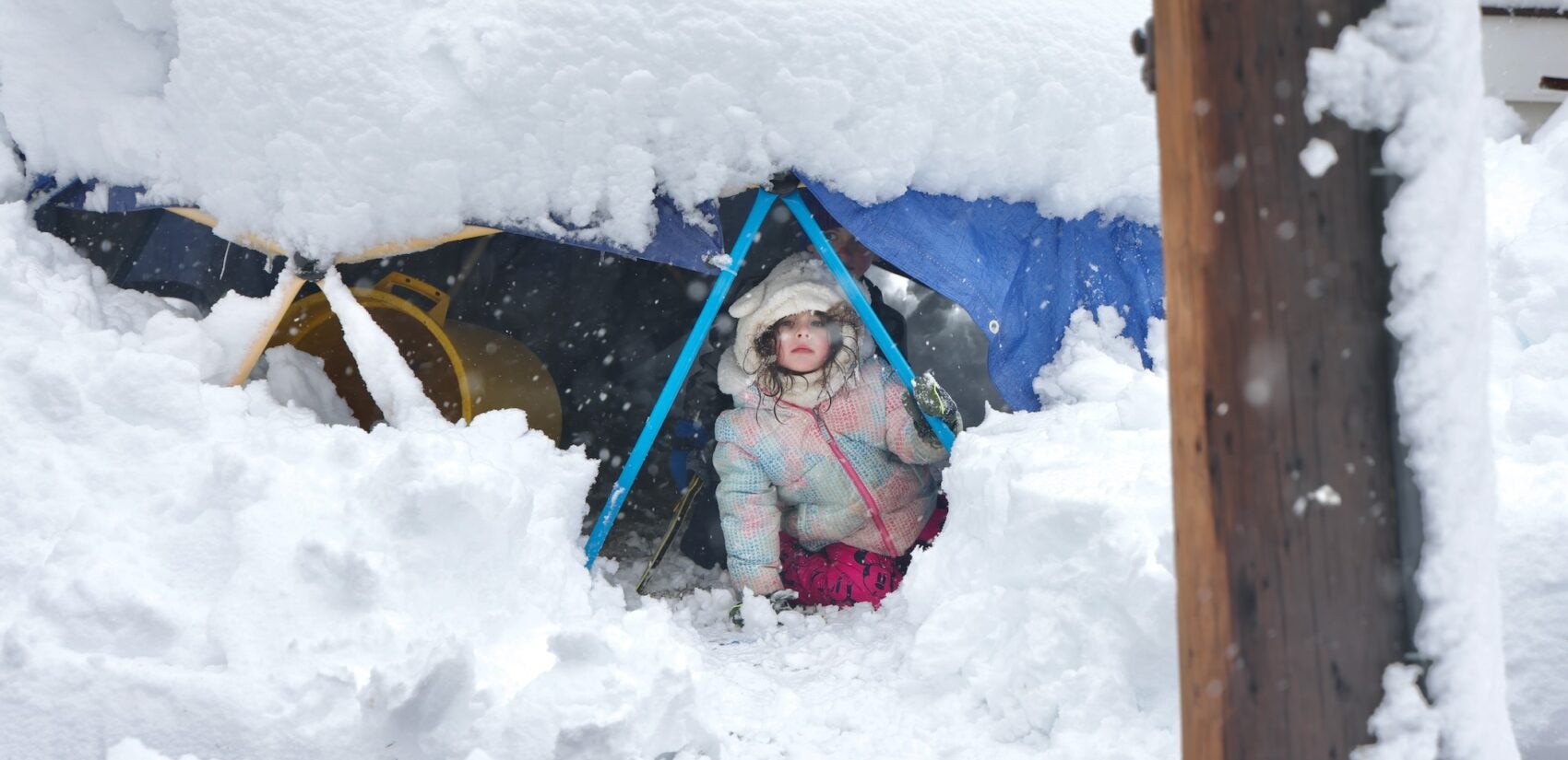 A young child peers out from a fort built in the snow in Moorestown, New Jersey