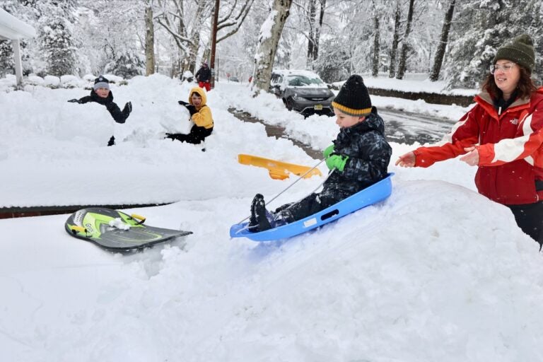 A child is being pushed down a small hill on a sled after huge snowfall in Moorestown, New Jersey