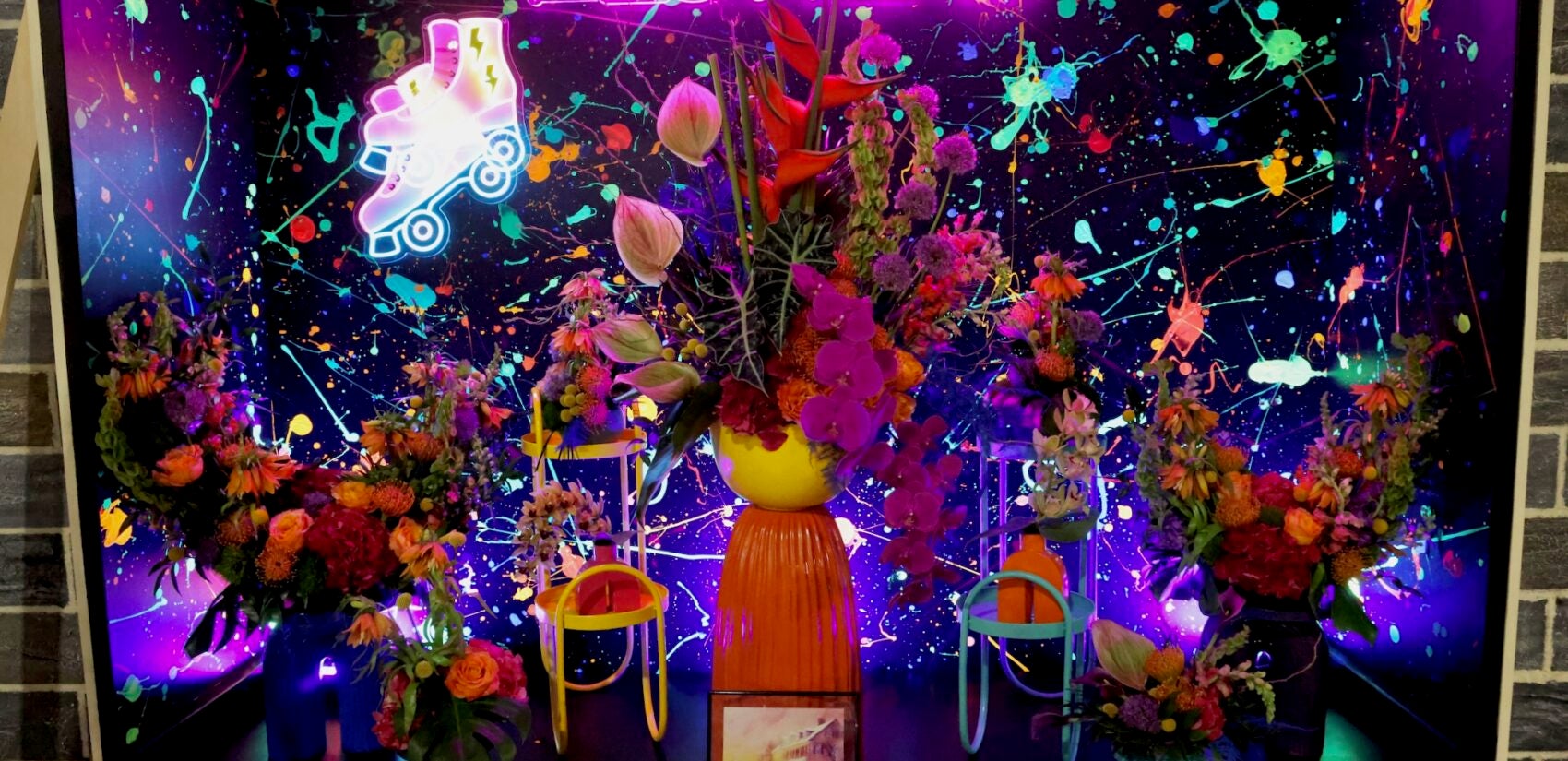 a neon sign says FLOWER with flowers in front of it