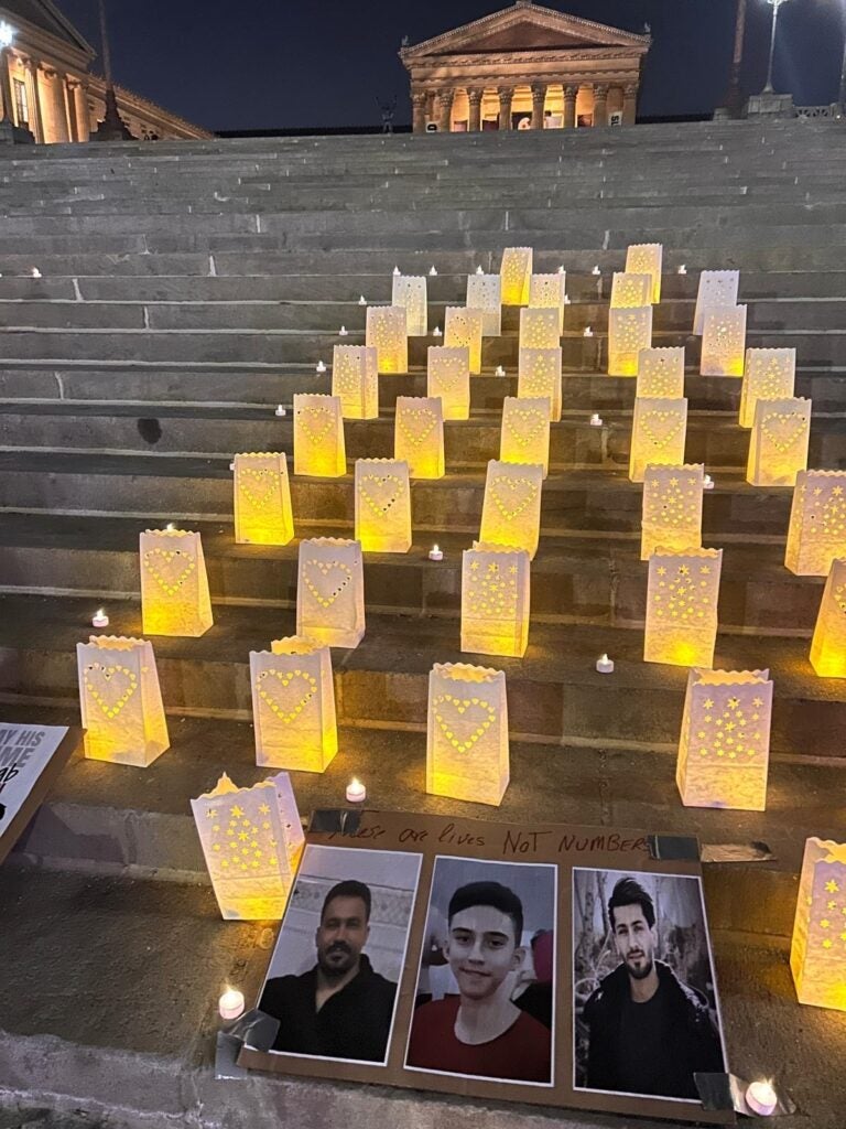 Candles are lit behind photos of people who were killed in Iran