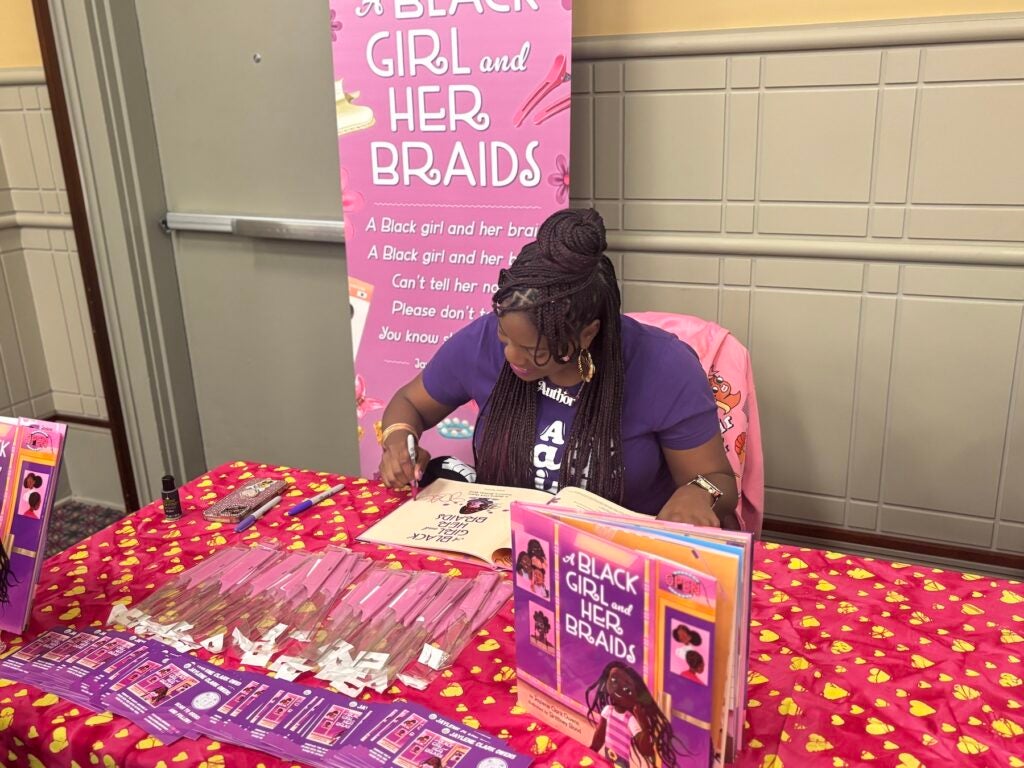 Author Jaylene Clark Owens signs a copy of her book