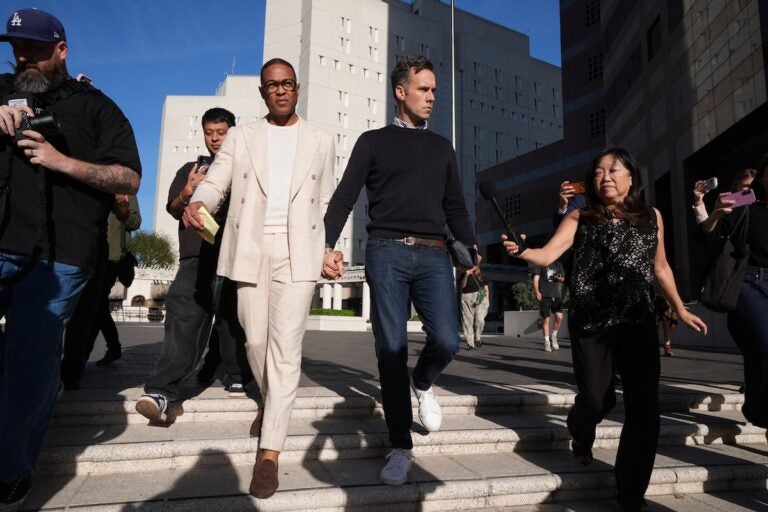 Journalist Don Lemon, holds hands with his husband Tim Malone leave after a hearing outside the Edward R. Roybal Federal Building in Los Angeles on Friday, Jan. 30, 2026. (AP Photo/Damian Dovarganes)