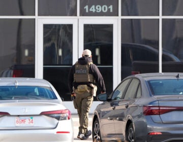 An ICE agent stands outside a warehouse