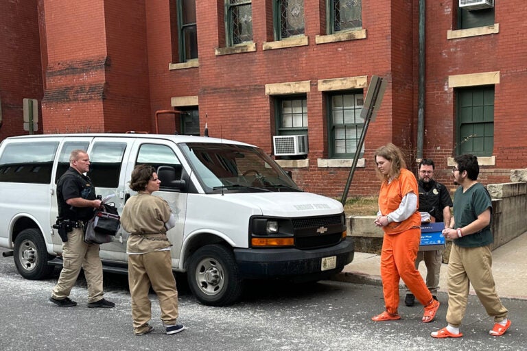 Deputies escort Michelle Zajko, left, Daniel Blank, right, and Jack LaSota, in orange, from the Allegany County Courthouse