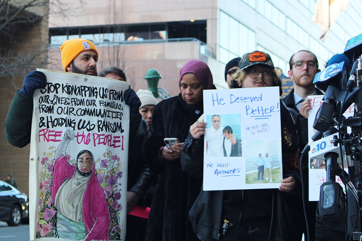 Several people holding up signs protesting the death of Parady La