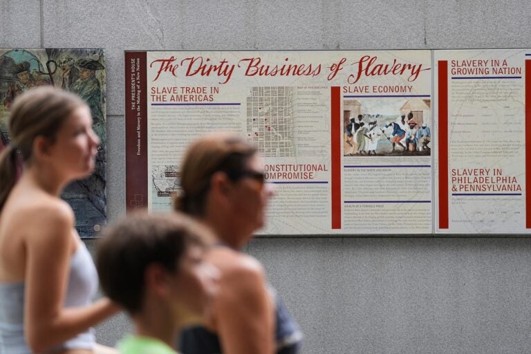 People walk past an informational panel at President's House Site Tuesday, Aug. 19, 2025, in Philadelphia.