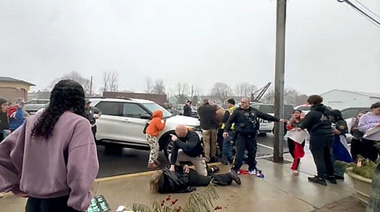 Quakertown police officers are seen Friday morning in this image taken from video arresting someone outside Sunday’s Deli & Restaurant, where students had gathered to protest against U.S. Immigration and Customs Enforcement.