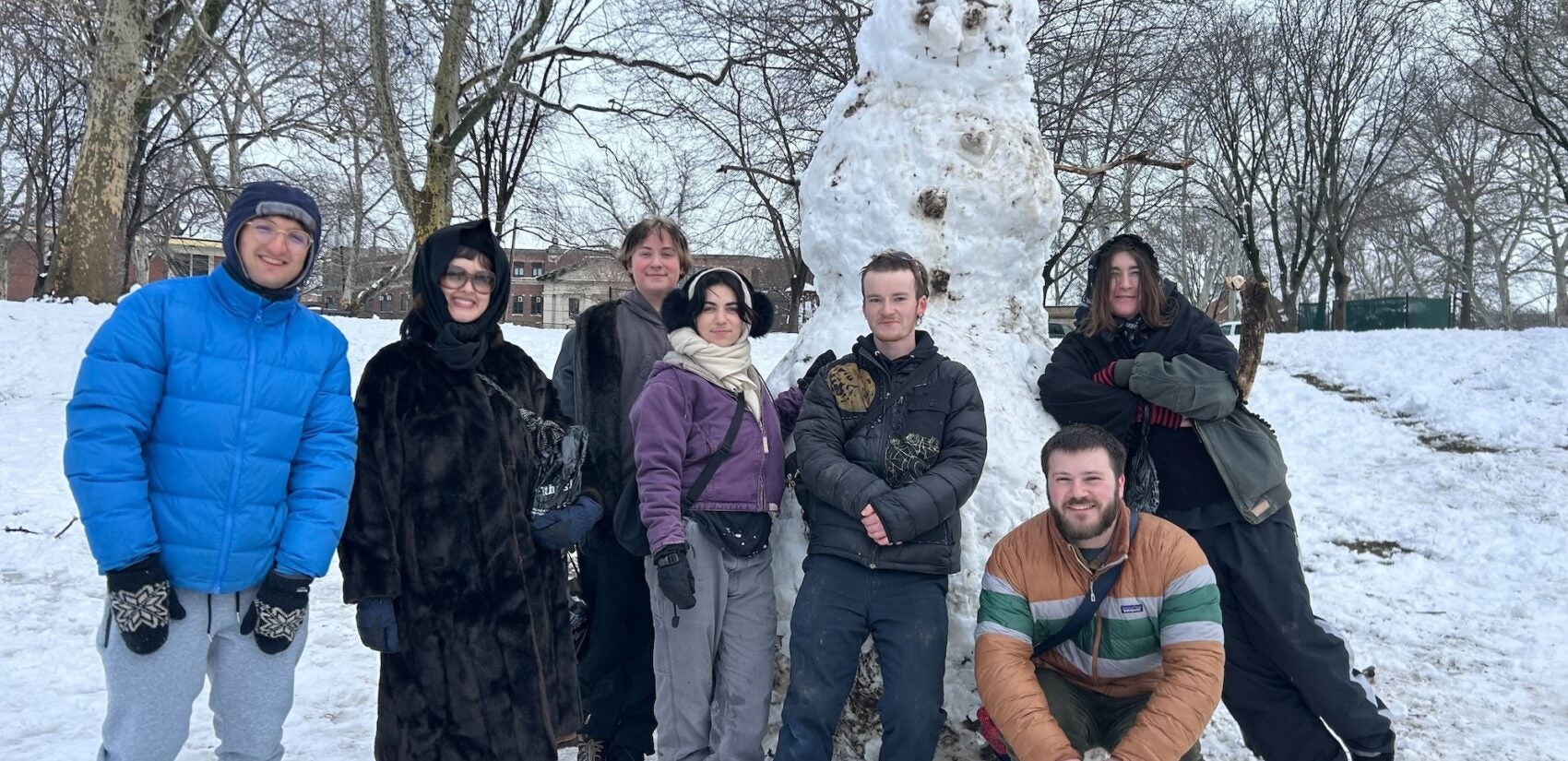 A group of people pose in front of the gigantic snowman they built in Clark Park after the snowstorm