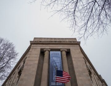 Trump Justice Department A large banner with Trump's face hangs on the side of a building