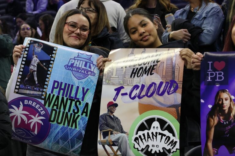 two fans hold signs