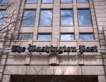 A sign above the entrance of the building for the Washington Post