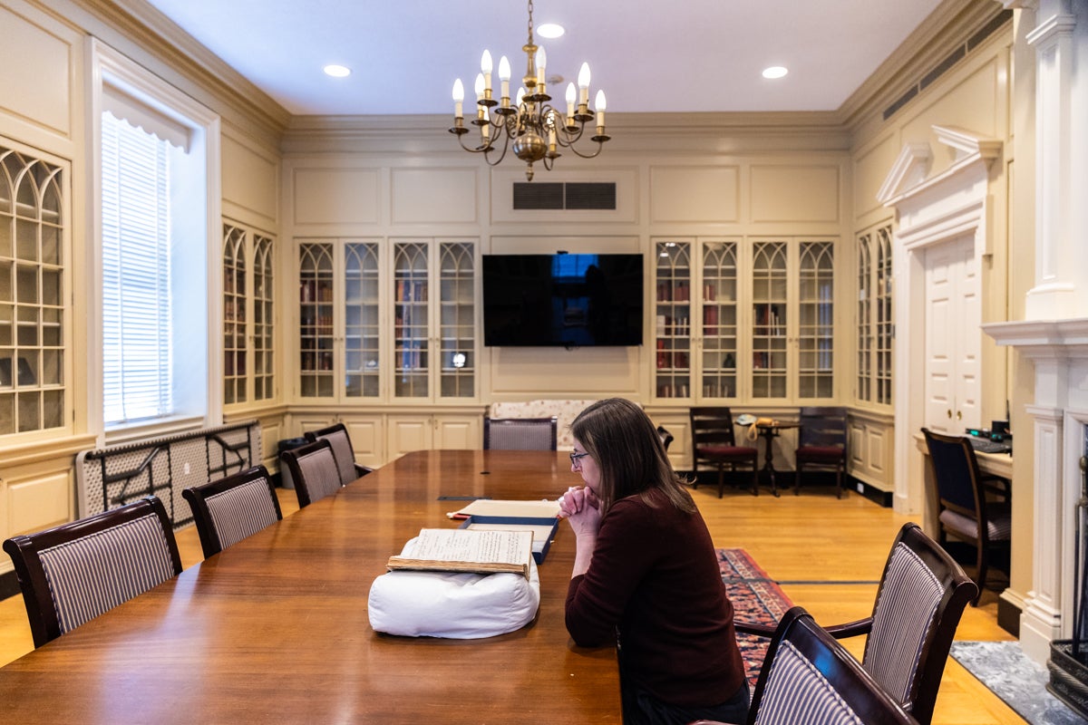 Adrianna Link at a table in the library reading a book