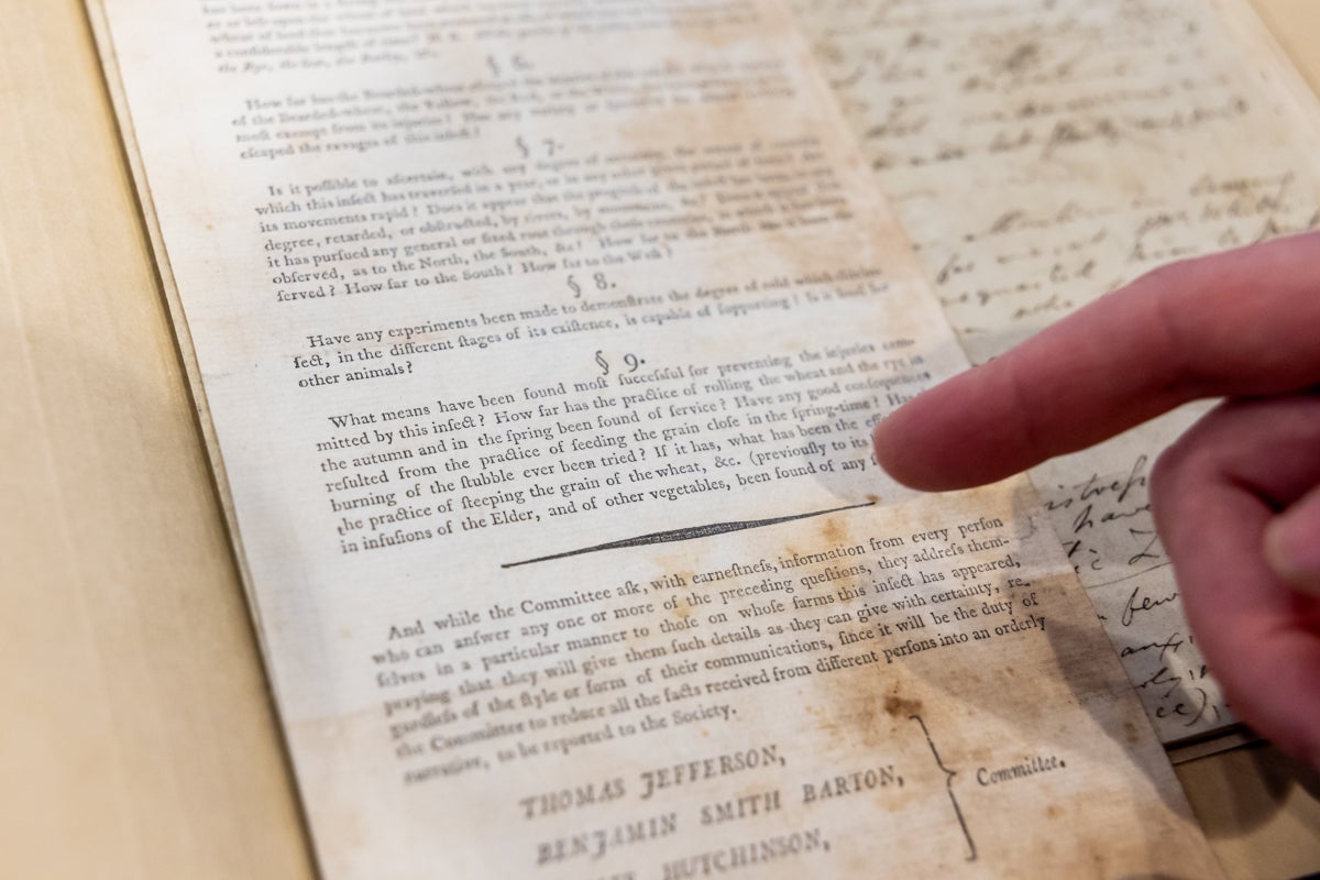 A person points to the words Hessian fly in the text of an old book.