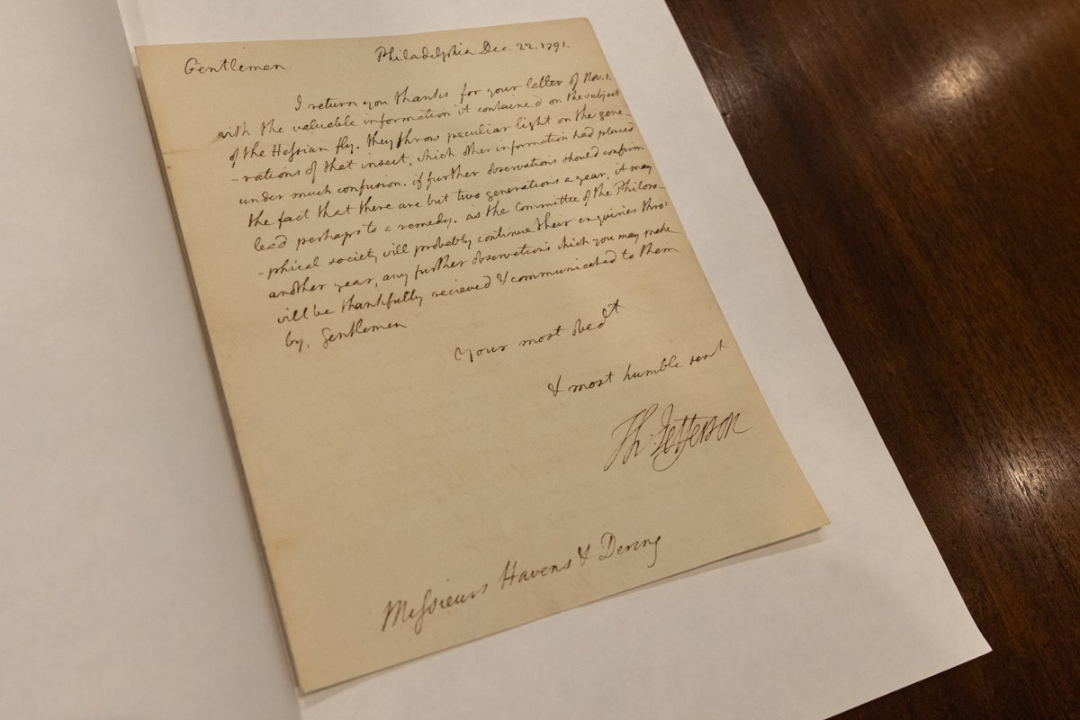 An old piece of paper with a handwritten note on it sits on a table