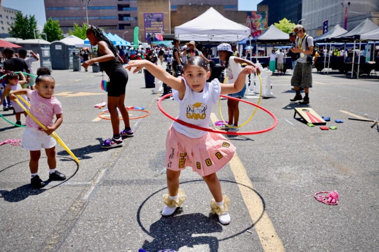 A 5-year-old hula hoops at a block party