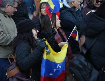 People hold Venezuelan flags outside the Cathedral Basilica of Saints Peter and Paul