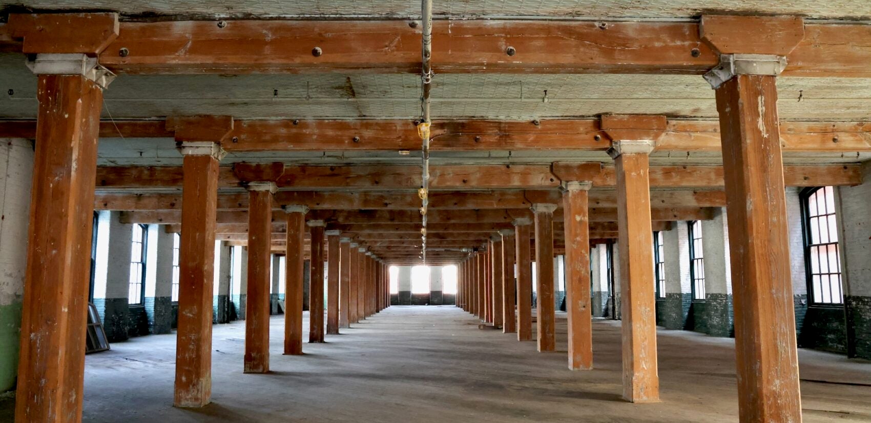 The empty interior of the old building, showing the wooden support beams.