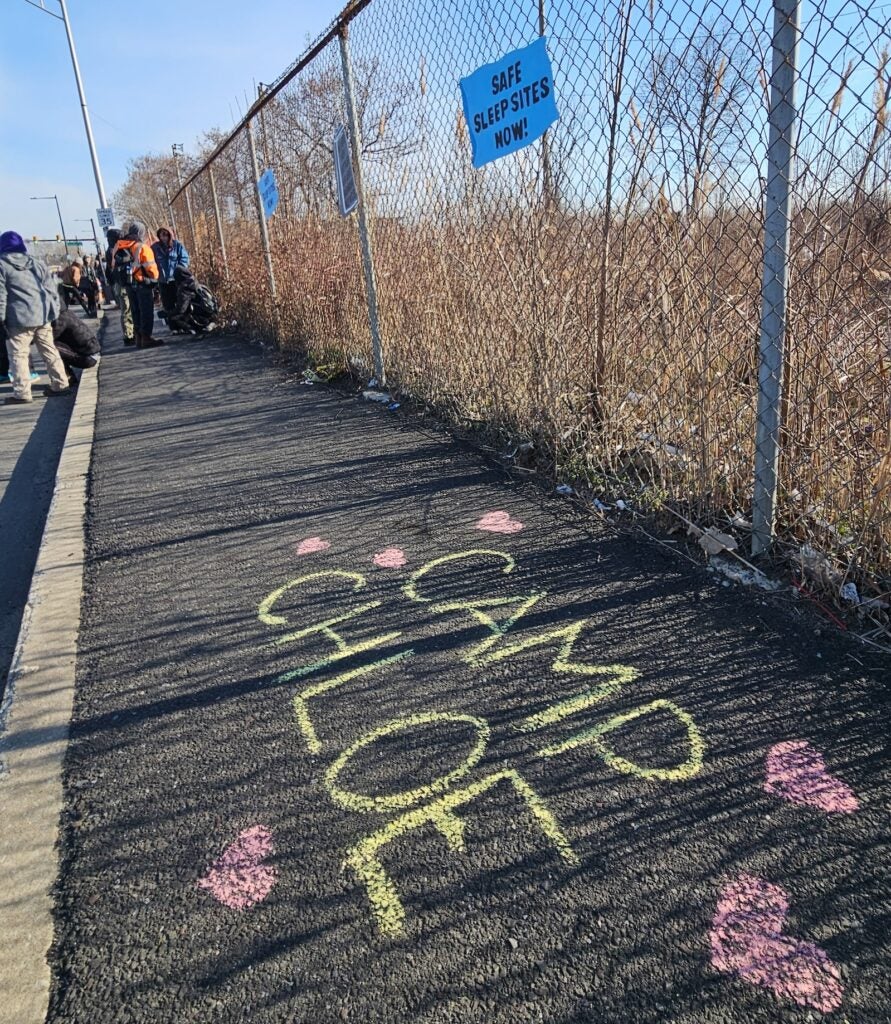 Camp Chloe is written on the sidewalk in yellow chalk, surrounded by pink hearts.