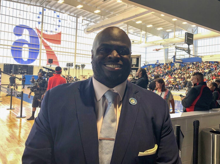 Tony Allen posing for a photo wearing a suit and tie.