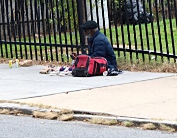 A man sits on a sidewalk