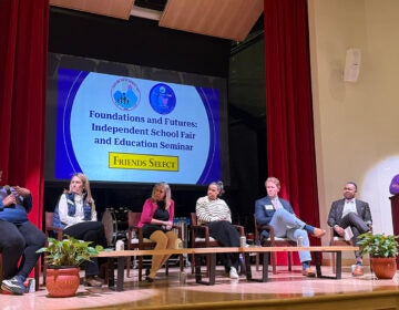 A panel of independent school leaders sit on a stage during a discussion