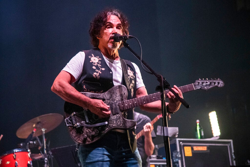 John Oates plays guitar on stage