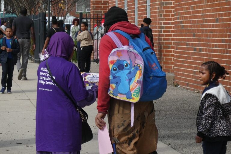 Students and parents outside Bluford Elementary School with Lift Every Voice Philly promoters