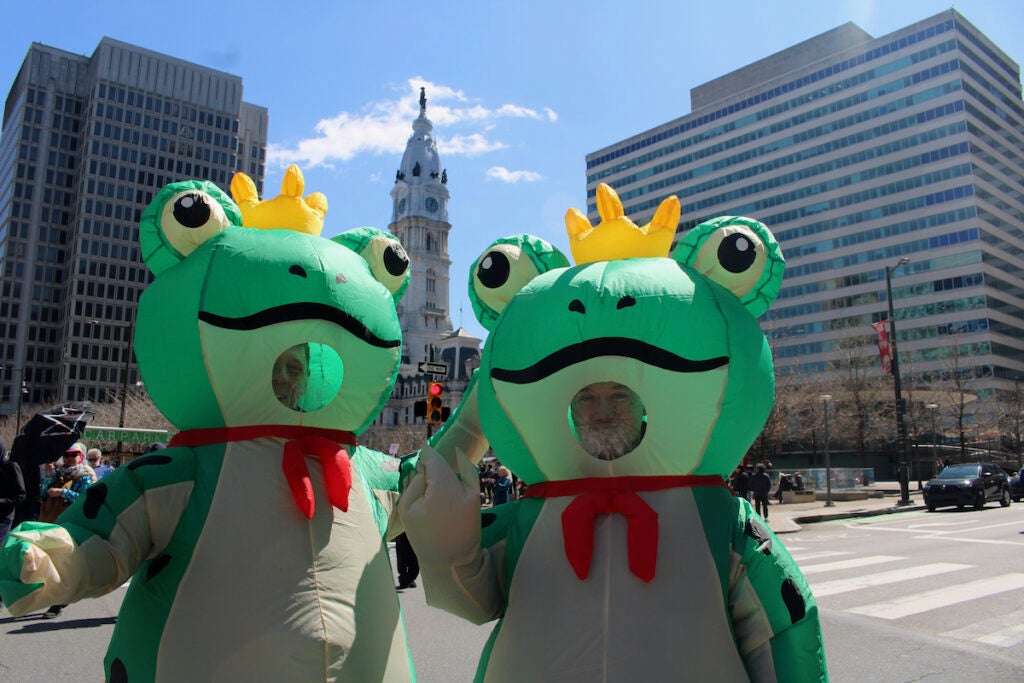 Two people dressed as frogs pose for a photo during a protest in Philadelphia against the Trump administration