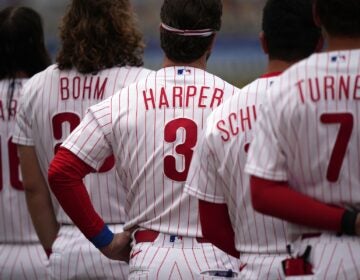 Philadelphia Phillies' Bryce Harper stands with his teammates