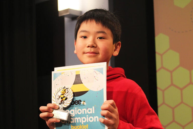 Jayden Jiang, a sixth grader at Girard Academic Music Program, holds up a sign showing he won the WHYY-Billy Penn Philadelphia Regional Spelling Bee