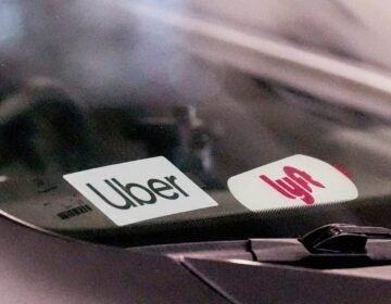 Uber and Lyft stickers are seen on a rideshare vehicle