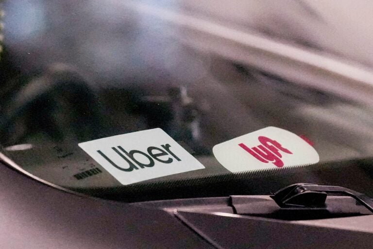 Uber and Lyft stickers are seen on a rideshare vehicle