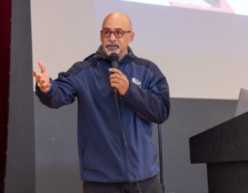 Chris Rabb addressing the crowd holding a microphone