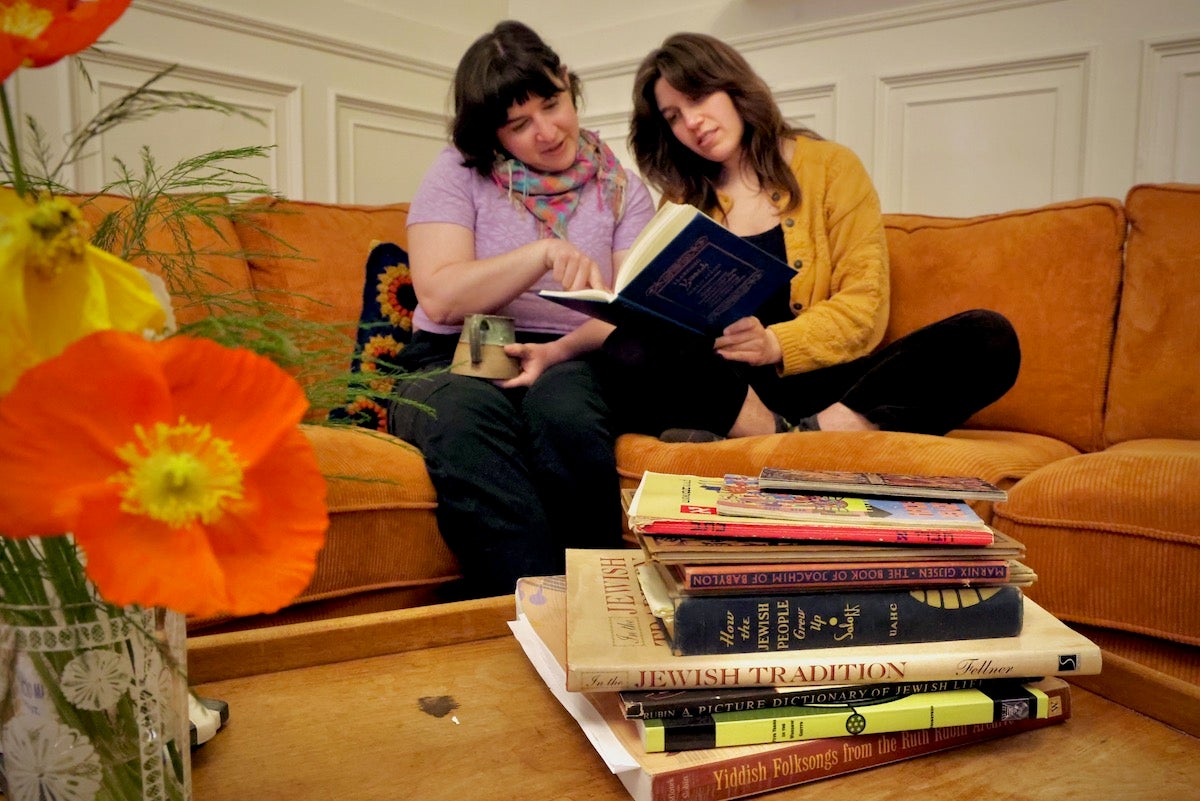 Miryam Coppersmith (left) and Maddie Rabin look at a book together