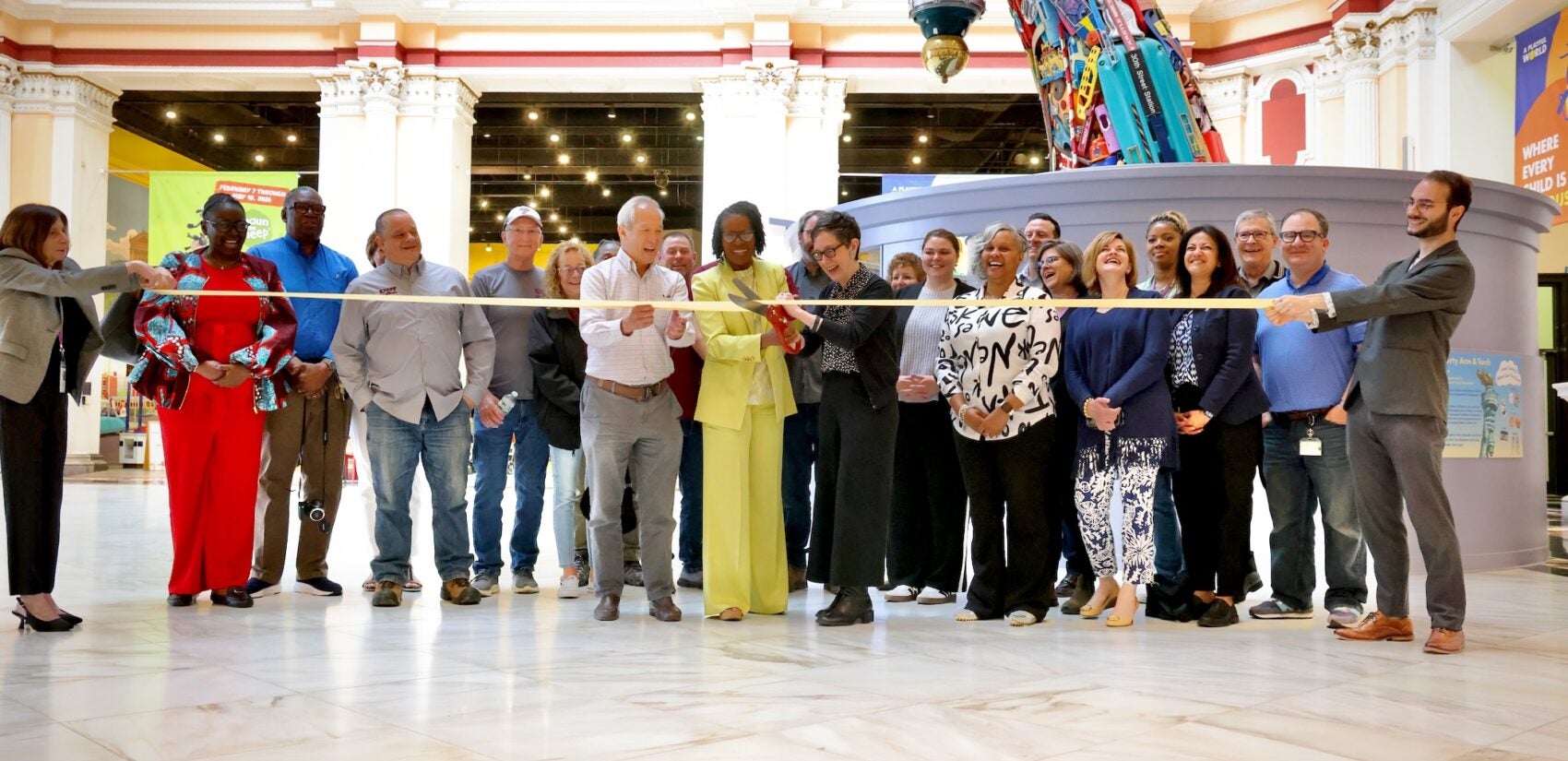 Please Touch Museum President and CEO Melissa Weiler Gerber cuts a ribbon surrounded by others