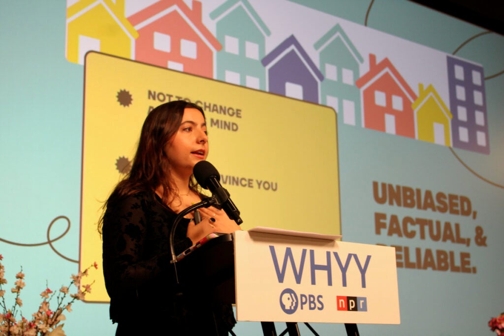 Brisa Luzzi Castro, community convener, WHYY News Community and Engagement Team, speaks into a microphone at the WHYY Civic News Summit