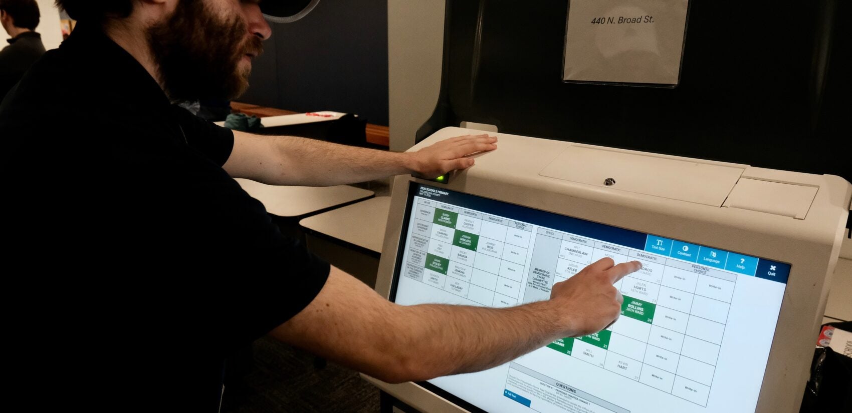 A city worker demonstrates how to use a voting machine