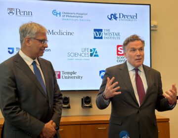 NIH director Jay Bhattacharya (left) listens as Sen. Dave McCormick