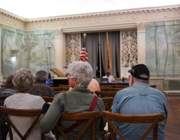 People sitting in the audience during a town hall meeting.
