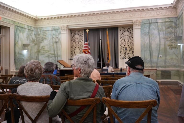 People sitting in the audience during a town hall meeting.