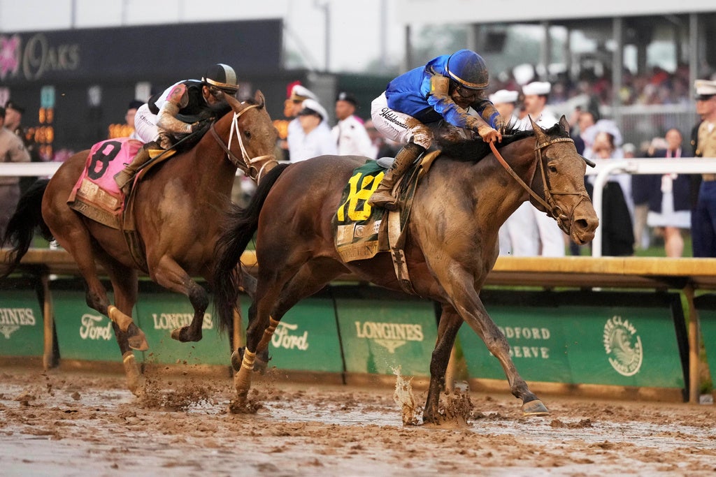 Sovereignty, right, ridden by Junior Alvarado, crosses the finish line to win the 151st running of the Kentucky Derby horse race followed by Journalism, ridden by Umberto Rispoli