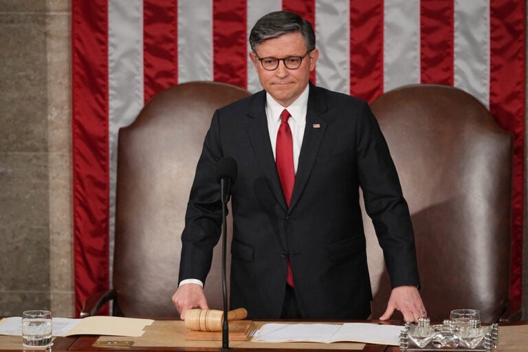 House Speaker Mike Johnson stands behind a podium