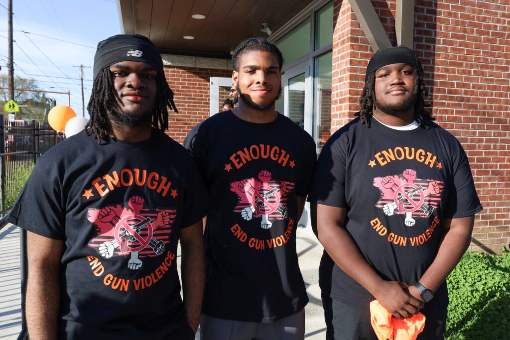 Zion Rhoden, James McClan and Kai Sample pose for a photo, and all are wearing matching anti-gun violence shirts