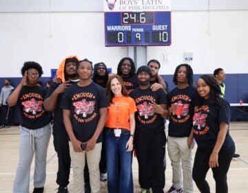 Sophia Collins posing on the basketball court with students.